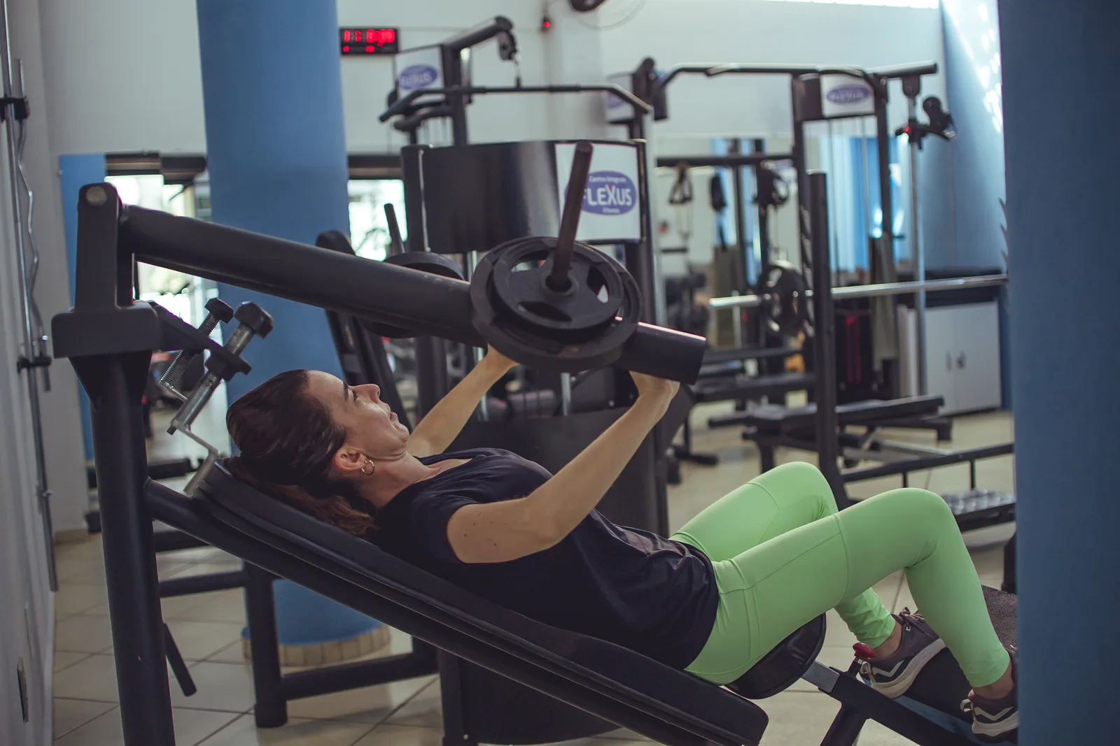 Aluna realiza musculação personalizada em equipamento da Flexus