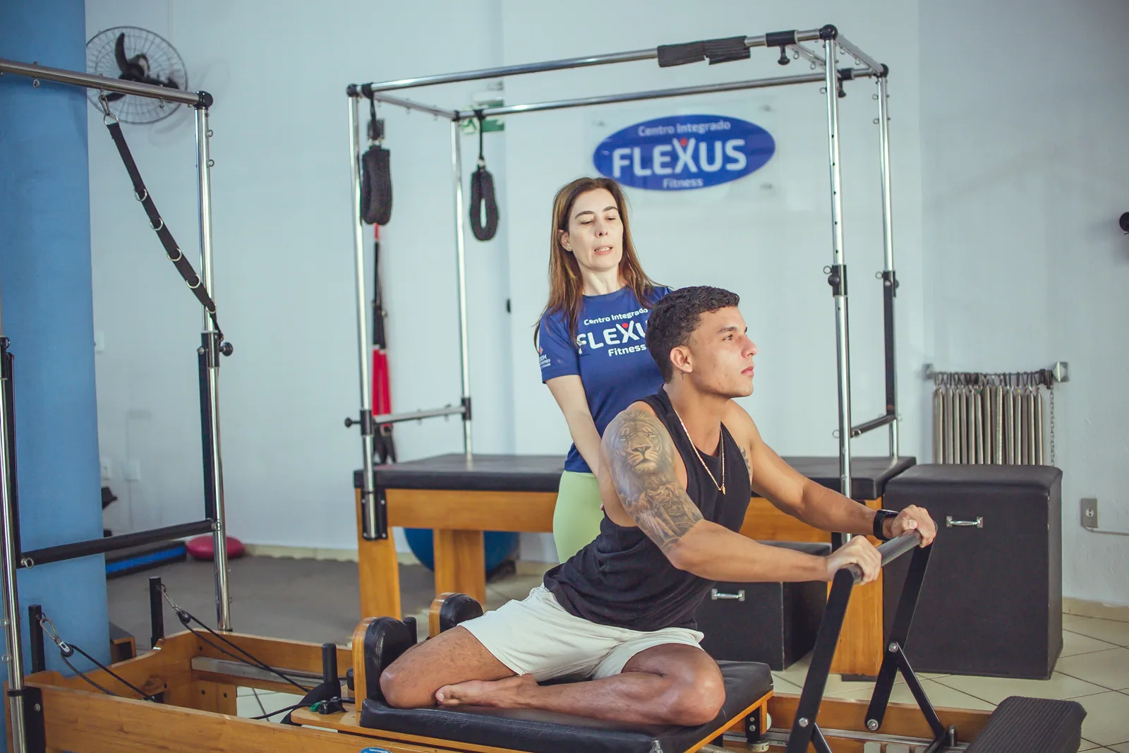 Profissional da Flexus acompanha aluno durante exercício de Pilates